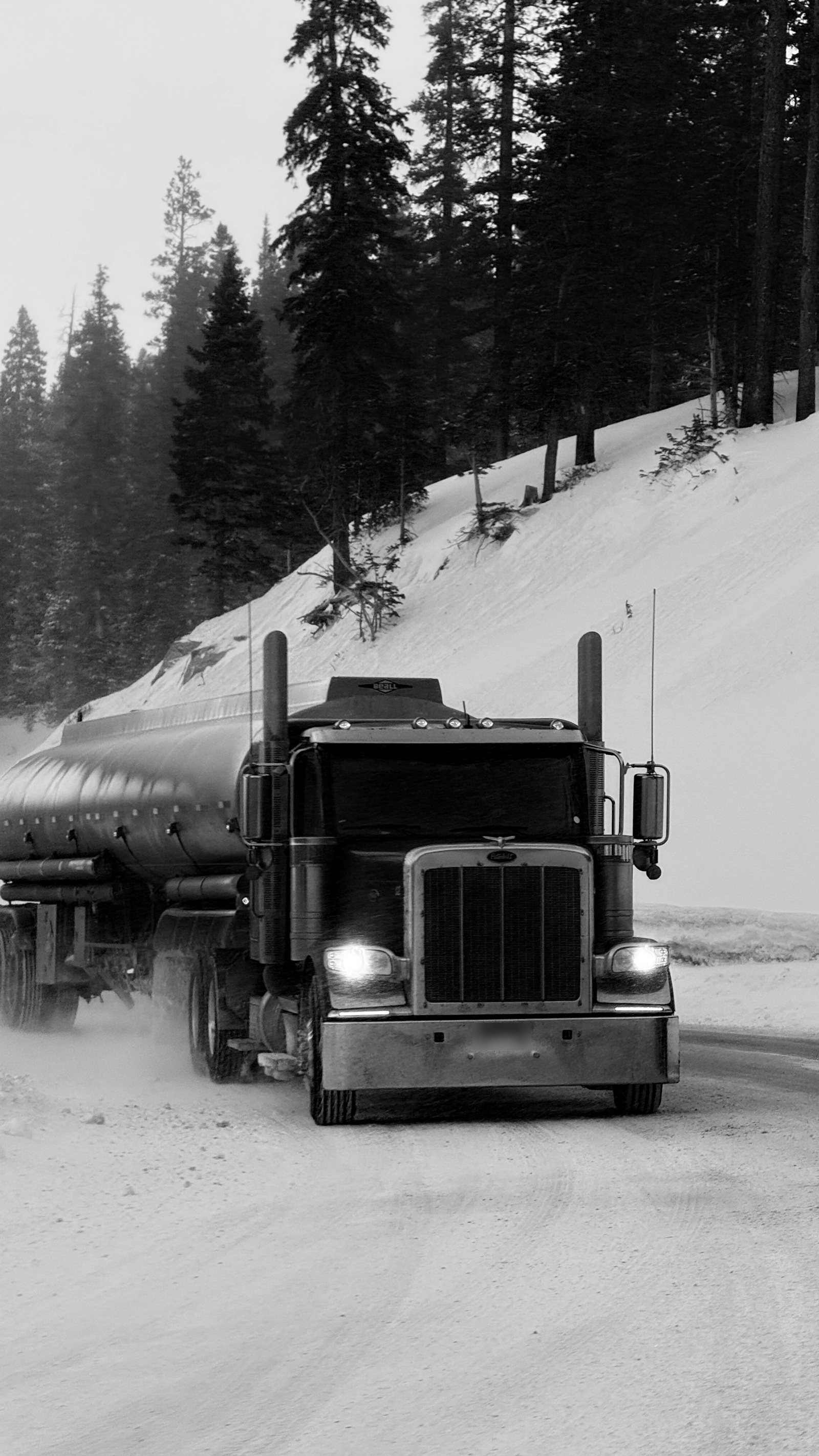 A tanker truck on a snow-covered mountain road