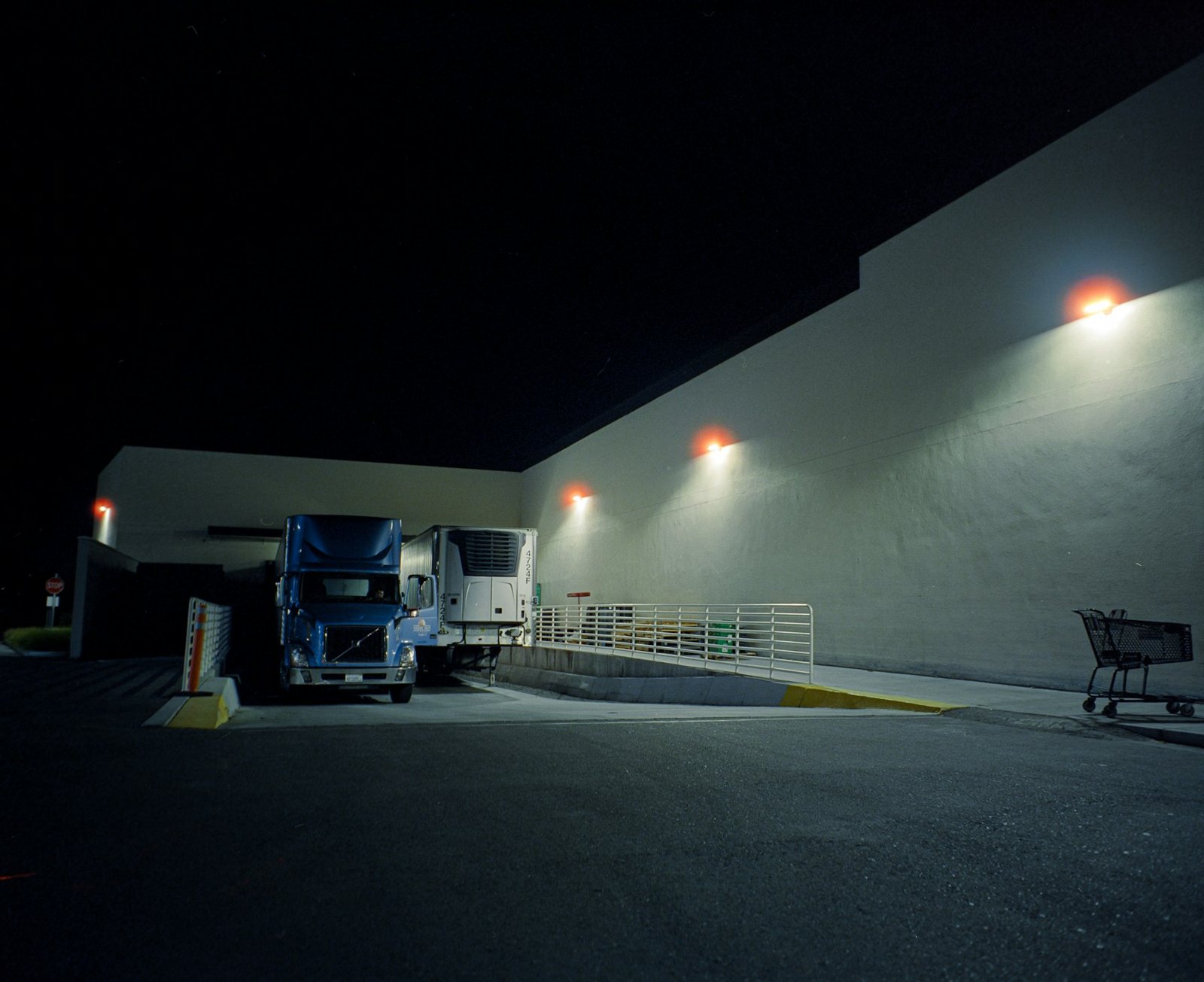 A tractor-trailer at a loading dock at night
